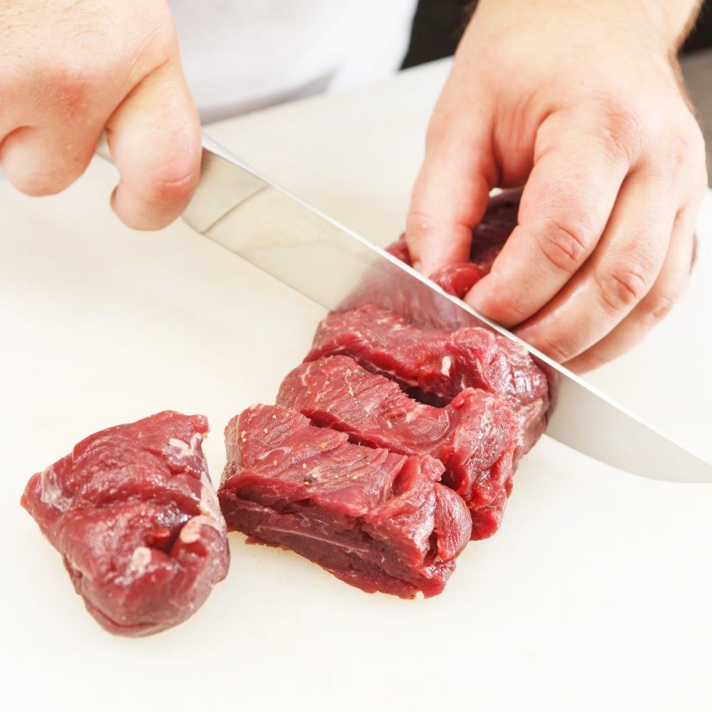 Boucher coupant la viande en morceaux